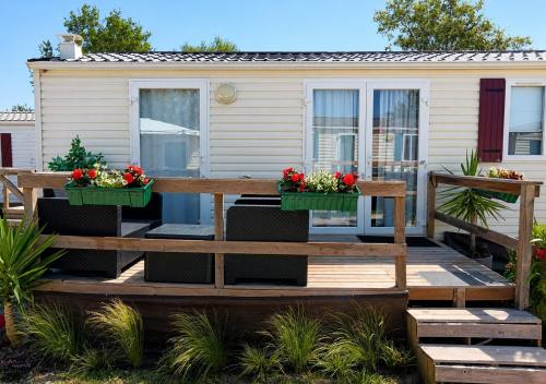 a wooden deck with two flowerpots and a caravan at Casa Nature's Avlis Bungalow 4XZ in Pataias