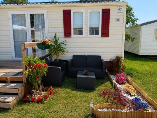 a backyard with a couch and flowers in front of a house at Casa Nature's Avlis Bungalow 4XZ in Pataias