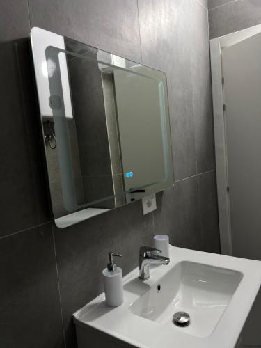 a bathroom with a white sink and a mirror at Lunea Apartment Palm Residence in Vlorë