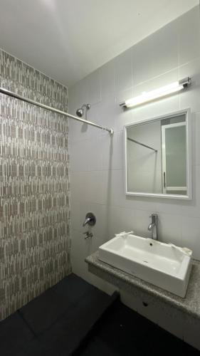 a bathroom with a sink and a mirror at Melati Hotel in Tanjungredep
