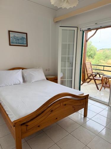 a bedroom with a wooden bed and a balcony at Molyvos Sunset Horizon in Mythimna