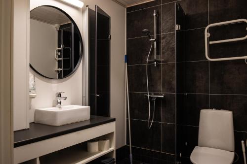 a bathroom with a sink and a shower at Tanhuvaaran urheiluopisto & Sport Resort in Savonlinna