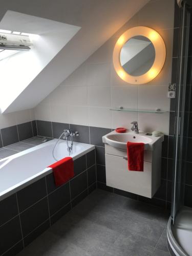 a bathroom with a sink and a tub and a mirror at Apartments Šimákova Vila in Turnov