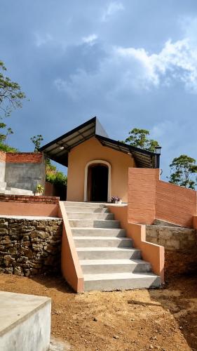 a house with stairs leading up to a building at Glamping by CampingLyfe in Bandarawela