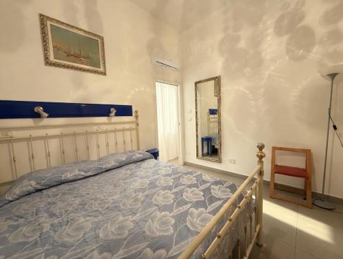 a bedroom with a bed and a mirror and a chair at Corso79 in Porto Santo Stefano