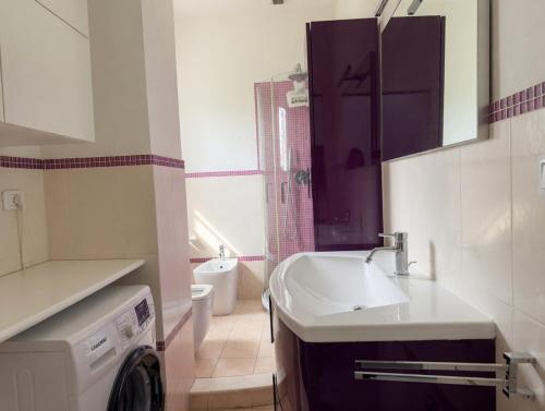 a bathroom with a sink and a washing machine at Corso79 in Porto Santo Stefano