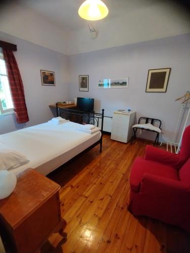 a bedroom with a large bed and a red couch at Philoxenia in Spata