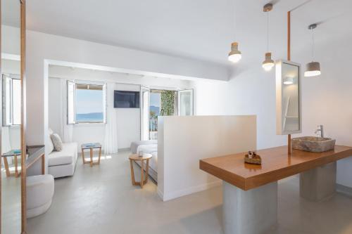 a white living room with a table and a couch at Santana Beach in Agia Anna Naxos