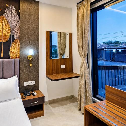 a bedroom with a bed and a window with a view at Hotel Aroma in Mathura