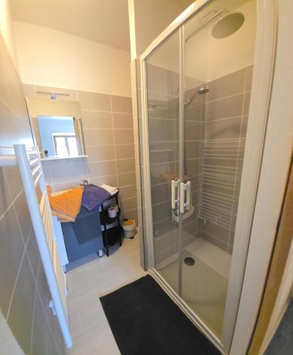 a bathroom with a shower with a glass shower stall at Le Relais d'Heugnes in Heugnes