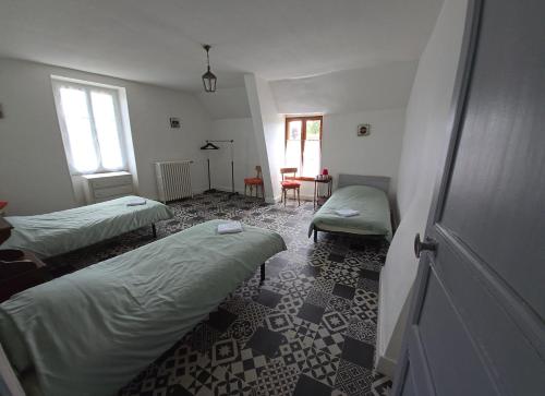a room with two beds and a table in it at Le Relais d'Heugnes in Heugnes