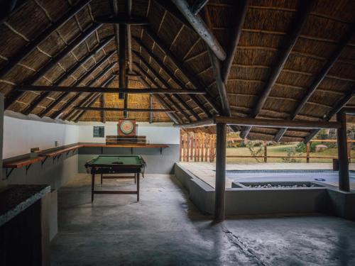 a room with a pool and a table in it at Pinewood Cottages in Renos