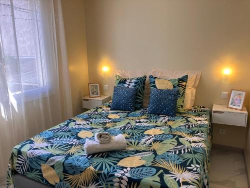a bedroom with a bed with a blue and white comforter at La Catalane in Perpignan