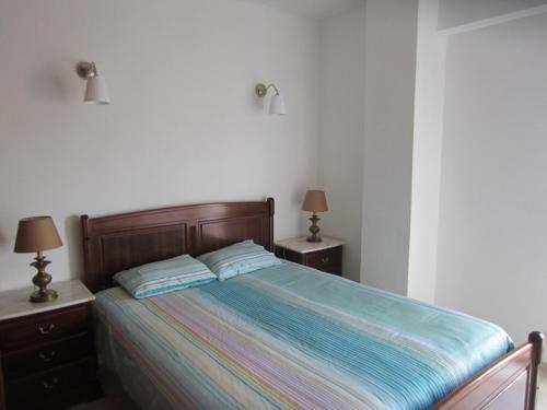 Apartment Torralta في ألفور: غرفة نوم بها سرير نفرين ومصباحين
