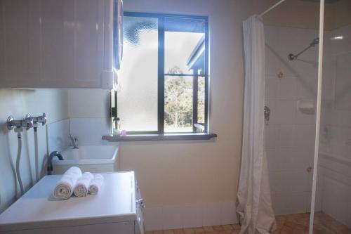 a bathroom with a tub and a sink and a window at #2 Walpole Wilderness Resort chalet. Spa + forest. in Walpole