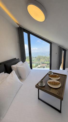 a bedroom with a table with plates of food on it at NEVO FAQRA Elevate Your Stay! in Ḩaqlat as Sayyid