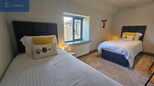 a bedroom with two beds and a window at Karadow in Saint Just in Roseland
