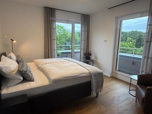 a bedroom with a bed and a large window at Premium Penthouse Parkblick in Bad Driburg