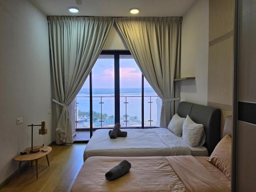 a bedroom with two beds and a large window at Country Garden Danga Bay By Widebed JB in Johor Bahru
