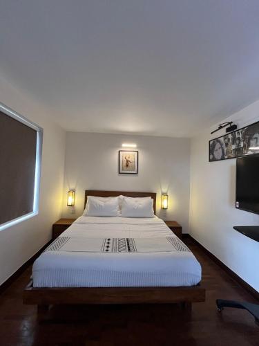 a bedroom with a large bed and a flat screen tv at Mi casa in Kathmandu