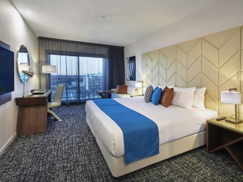 a hotel room with a large bed and a desk at The Sebel West Perth in Perth