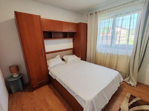 a bedroom with a bed and a cabinet and a window at Virajlux Verde Retreat in Mioveni