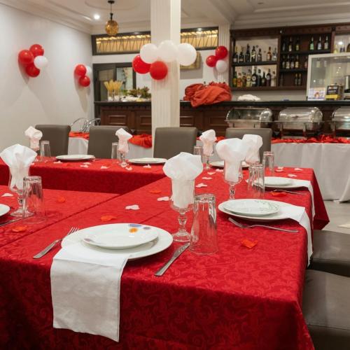 a table with red and white table cloths and utensils at Arenah hotel in Yaoundé