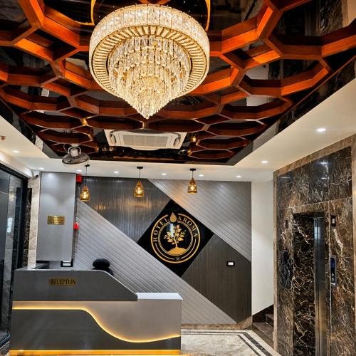 a lobby with a large chandelier and a desk at Hotel Aroma in Mathura