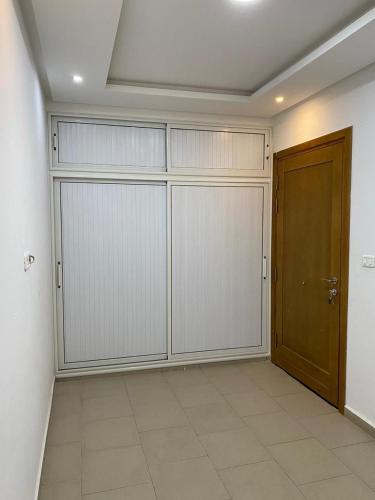a large closet with white doors in a room at Dar Frdj in Sousse
