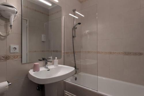 a white bathroom with a sink and a shower at 1D Albufeiras Baysight flat in Albufeira