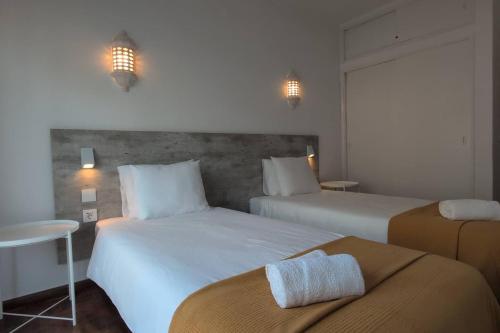 a hotel room with two beds and a table at 1D Albufeiras Baysight flat in Albufeira