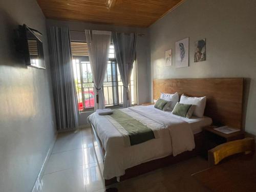 a bedroom with a large bed and a window at KIGALI FANTASTIC Aparthotel in Kigali