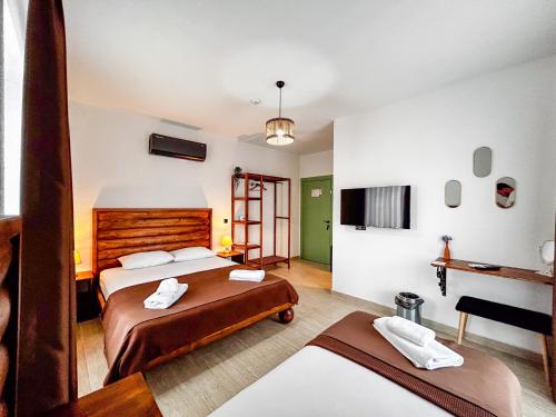 a hotel room with two beds and a television at Mlinova Küçükköy in Ayvalık