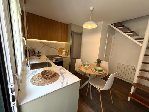 a kitchen with a sink and a table in a room at Casa Caracol in Cambados