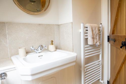 a bathroom with a white sink and a mirror at Riverside Cottage in Comrie