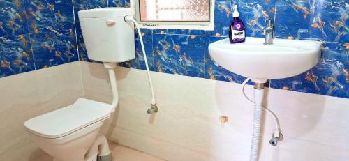 ein Badezimmer mit Toilette und Waschbecken in der Unterkunft Transit Nest 1BHK in Guwahati