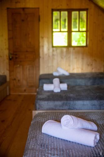 three beds in a room with towels on them at Gora Babilina in Gordi