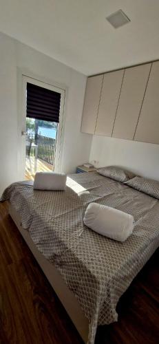 a bedroom with a large bed with two pillows on it at Mobile Homes Gasperino in Pirovac