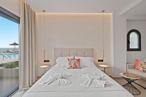 a bedroom with a white bed with a large window at Giorgos apartments in Dassia