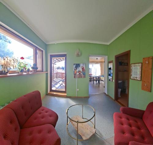 a living room with a red couch and a table at Monikas in Lapmežciems