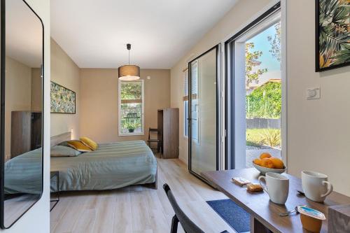 a bedroom with a bed and a table with a dining room at Chambre - Le Nid in Saint-Prouant