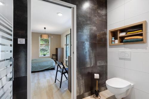 a bathroom with a toilet and a bedroom at Chambre - Le Nid in Saint-Prouant