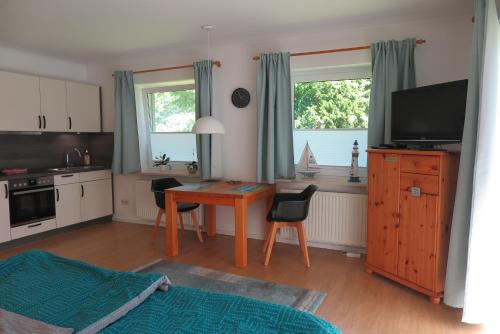 a kitchen with a desk and a table with a television at Apartment "An der Süderschmiede" in Sieverstedt