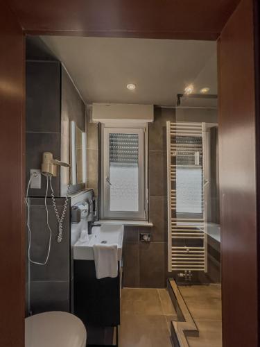 a bathroom with a sink and a toilet at Hotel Il Cavallino in Warendorf