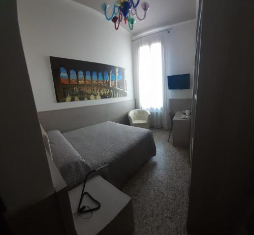 a small bedroom with a bed and a window at Foresteria Levi in Venice