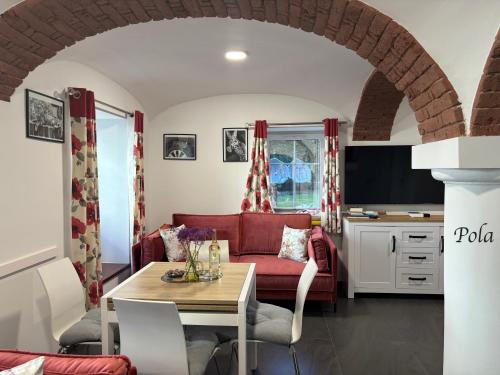 a living room with a red couch and a table at Słoneczne Apartamenty in Sokołowsko