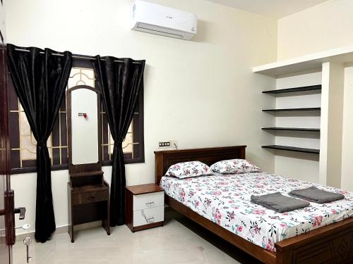 a bedroom with a bed and a window at SK Aarshan's Homestay in Tiruchirappalli