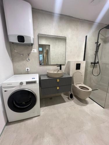 a bathroom with a washing machine and a toilet at Central nude oasis 2 in Makarska