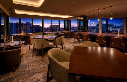 a restaurant with tables and chairs and a view of the city at Okinawa Harborview Hotel in Naha
