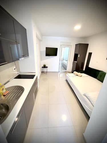 a large white room with a bed and a sink at Vip Villa Tina in Novalja